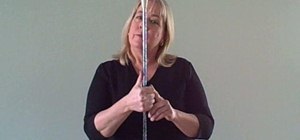 Do a thumb toss with a baton, staff or juggling club