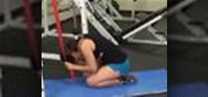 Do a resistance band crunching exercise while kneeling