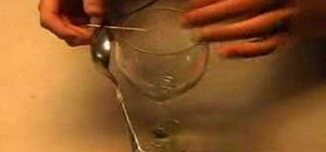 Balance a spoon and fork on a toothpick on a glass