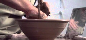 Throw a small ceramic mixing bowl on a pottery wheel