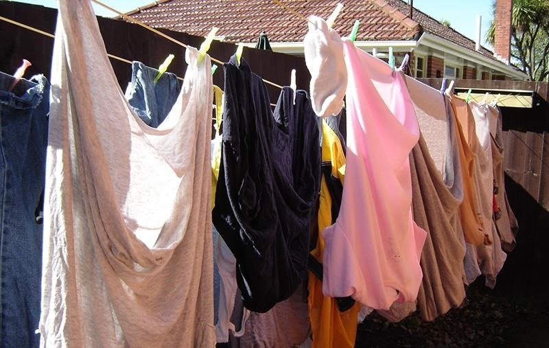 mngeringkan baju di bawah sinar matahari