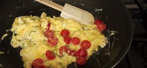Make summer scrambled eggs with cherry tomatoes, feta, and basil